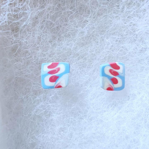 Two white, pink, and blue stud earrings