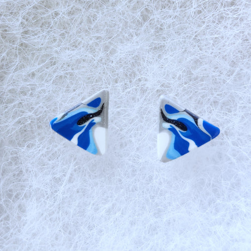 A pair of blue, silver, and white triangular earrings