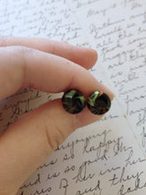 Load image into Gallery viewer, Yellow, black, and orange swirl earrings held between finger and thumb
