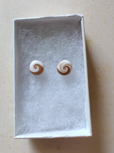Gold and white swirl earrings inside a white paper jewelry box