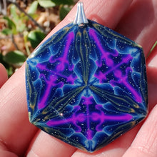 Load image into Gallery viewer, A large hexagonal pendant with a silver colored bail resting in a hand in the sunlight. The pendant is navy blue with veins of gold around the edges and radiating from the center in thirds. There are purple veins in the relative shape of a triangle throughout the pendant. 

