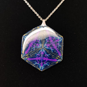 Light reflecting off a large glossy hexagonal pendant displayed on a black velvet background. The pendant is navy blue with veins of gold around the edges and radiating from the center in thirds. There are purple veins in the relative shape of a triangle throughout the pendant. 
