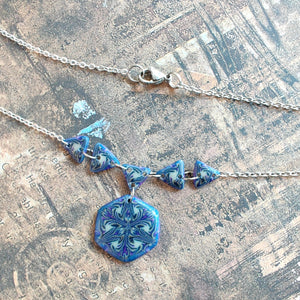 A close up view of the necklace showing small glitter details. 