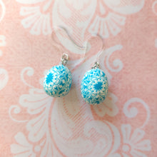 Load image into Gallery viewer, Patterned Easter egg shaped dangle earrings in a blue and white one a pink paper background.
